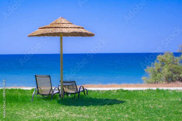 Obraz Einsamer Strand mit Sonnenschirm und Liegestühlen am Meer