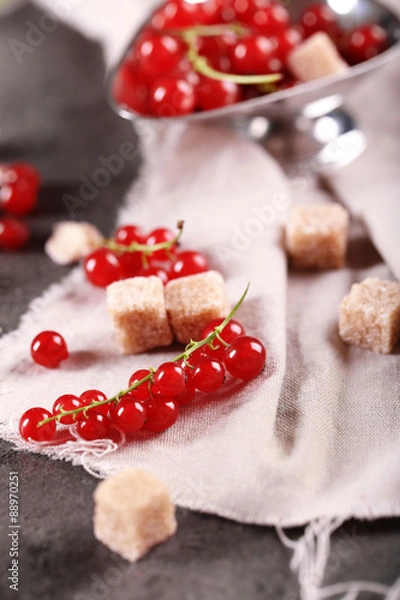 Fototapeta Ripe red currants with lamp sugar on table with sackcloth, closeup