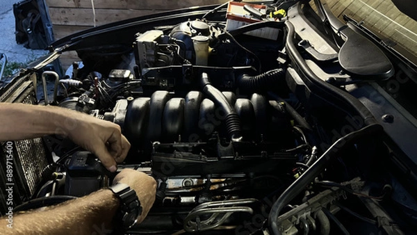 Fototapeta Auto mechanic working in garage. Repair service.