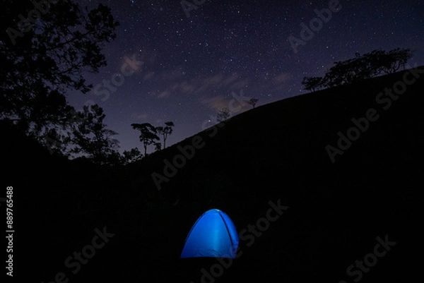 Obraz View of the center of the milky way with a blue illuminated camping tent