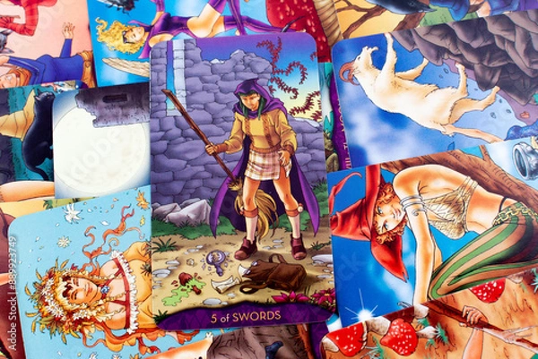 Fototapeta Tarot cards, Waite Rider tarot cards, the five of swords card in the foreground on a background of available deck cards