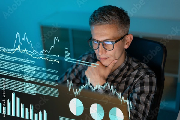 Fototapeta Focused Analyst Examining Data Visualizations and Charts on Screen