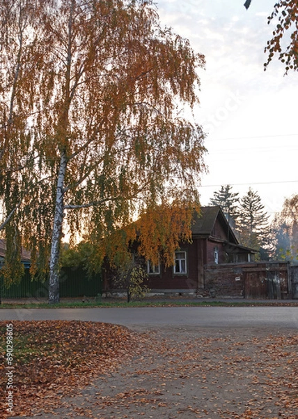 Fototapeta View of an old wooden house at sunset in autumn