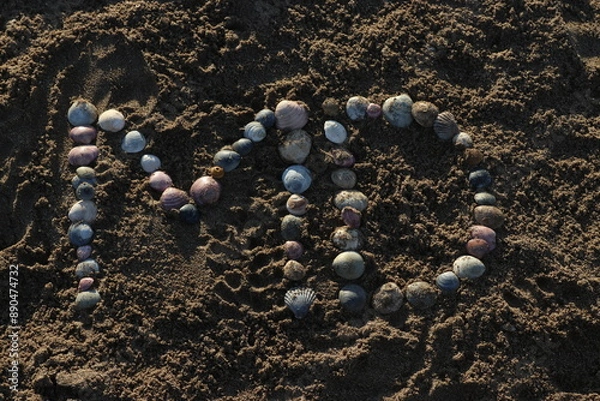 Obraz Letras creadas con ostras sobre la arena