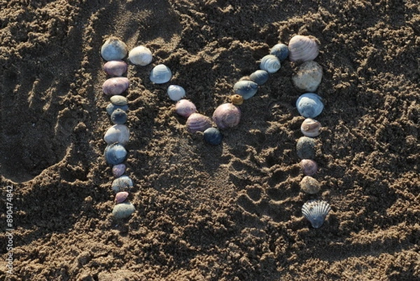Obraz Letras creadas con ostras sobre la arena