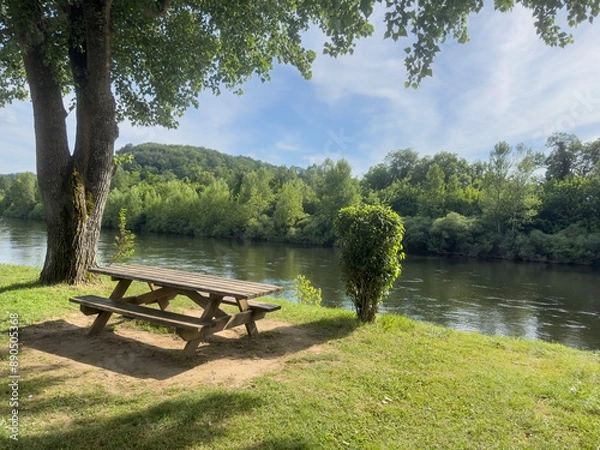 Fototapeta empty wooden picnic table in the park by river