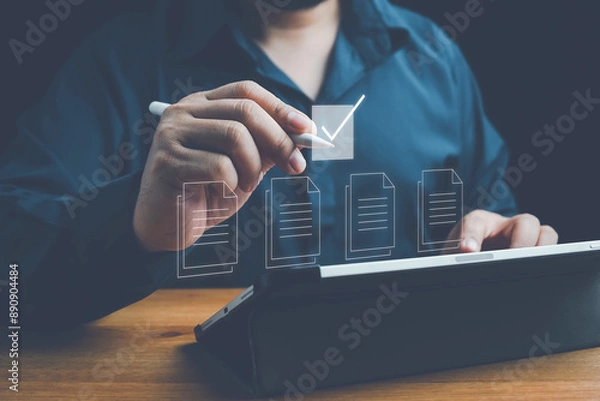 Fototapeta Document management concept, Businessman using laptop with online quality assurance approval document. Verifying electronic documents on digital documents, paperless document management system.