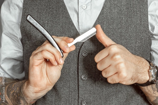 Obraz Barber testing the sharpness of a blade