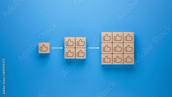 Fototapeta Wooden blocks with thumbs up icon on blue background, approval and success multiplication represented by increasing blocks, social media likes and positive feedback concept