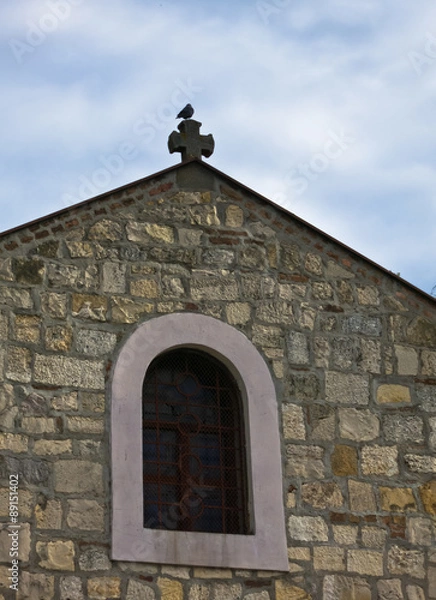 Fototapeta Pigeon sitting on a cross of a church at Kalemegdan fortress