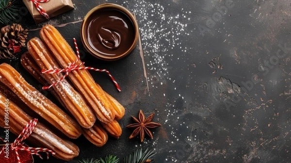 Fototapeta Festive churros placed on a rustic table with a bowl of chocolate sauce, pine cones, and Christmas decorations. Perfect holiday treat.