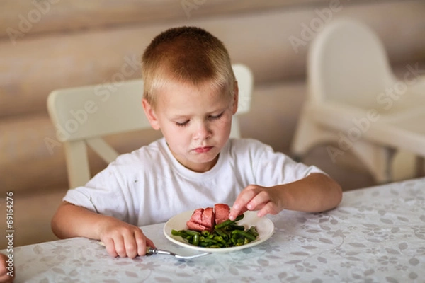 Fototapeta child eats at the table