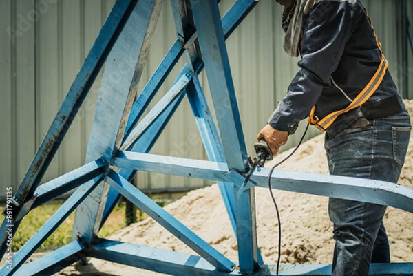 Obraz worker to cutting steel in construction site with Reciprocating saw or recip saw, saw used in construction and demolition work without creating any sparks.