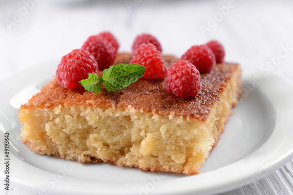 Fototapeta Fresh pie with raspberry in white plate on wooden table, closeup