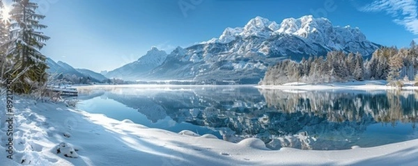 Obraz Snowy mountains mirrored in a serene lake, evergreen trees on the shore, bright winter day, isolated background for seasonal and holiday themes, copy space.