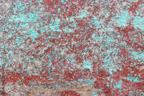 Fototapeta Grunge aqua and burnt red ochre peeling paint background texture. Abstract, vintage dappled backdrop for graphic design or social media. Chipped multi colour paint on external, rough concrete wall.