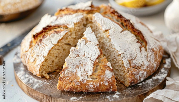Fototapeta A loaf of bread on a cutting board with a missing slice, common in recipes and as a staple food