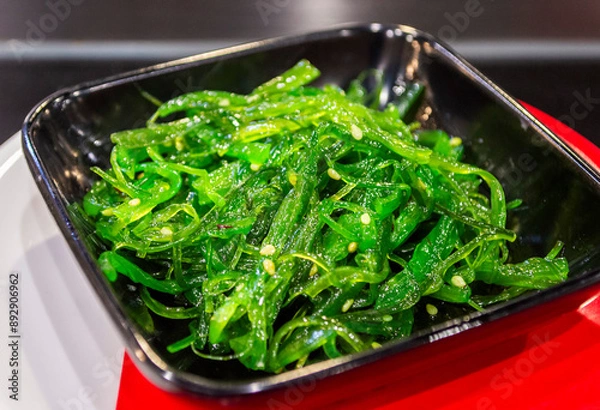 Fototapeta Top view of fresh green Japanese seaweed salad in a black plate