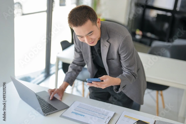 Obraz Business people holding Smartphone working mobile devices. cell telephone technology e-commerce concept.