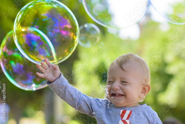 Fototapeta Cute Baby Catching Soap Bubbles