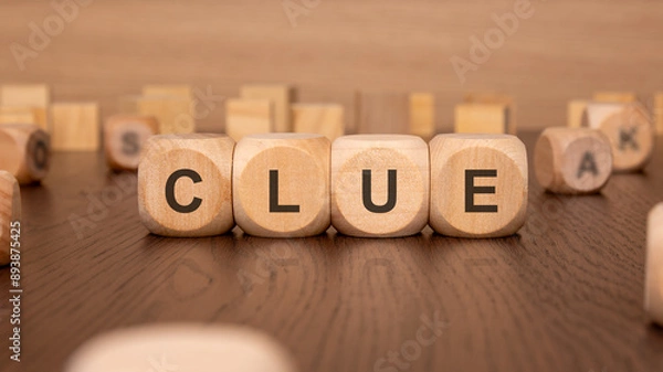 Fototapeta four wooden cubes with the text 'CLUE' on a brown background