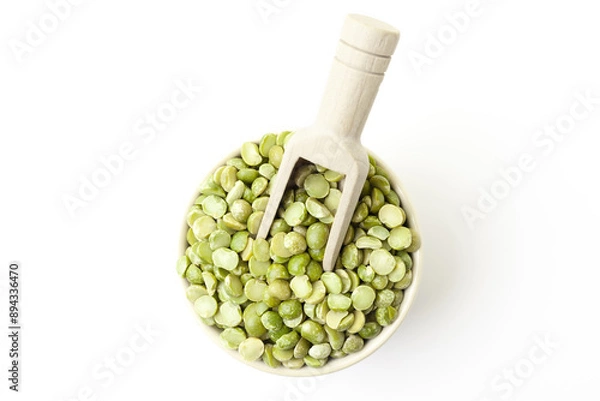 Fototapeta Dry, green peas in bowl with wooden scoop on white background. Top view