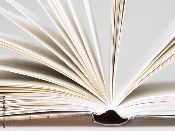 Fototapeta Close-up of open book pages filled with text. An ideal image for themes of literature, reading and knowledge