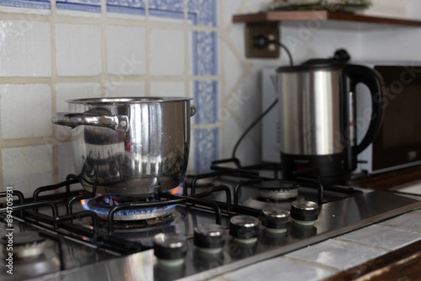 Obraz A pot sits on a stove burner with a flame underneath