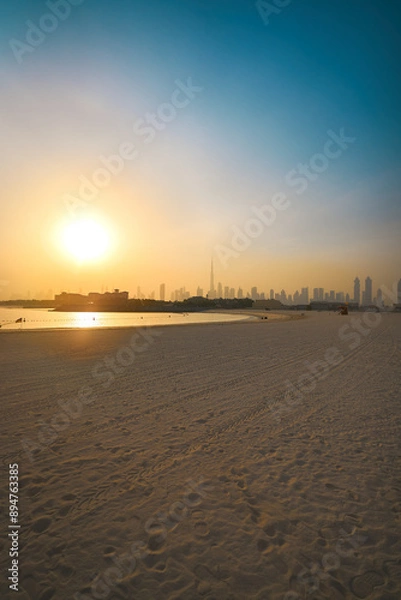 Obraz View of sunrise over a beach in Dubai overlooking Dubai skyline