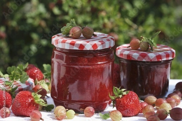 Fototapeta Two jars of strawberry and gooseberry jam and fruit