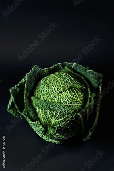 Obraz A savoy cabbage against a black background
