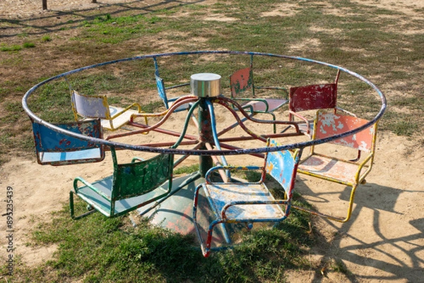 Fototapeta Rusty Vintage Merry-Go-Round in a Playground Evokes Nostalgic Childhood Memories