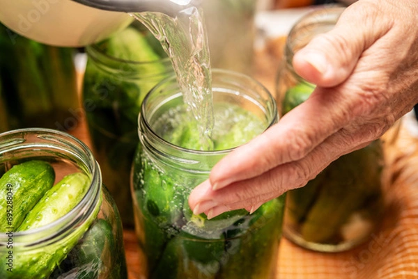 Fototapeta Traditional Salt Pickling Process of Fresh Cucumbers in Glass Jars