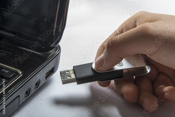 Fototapeta Ręczne wkładanie pamięci USB przyklejają się do laptopa