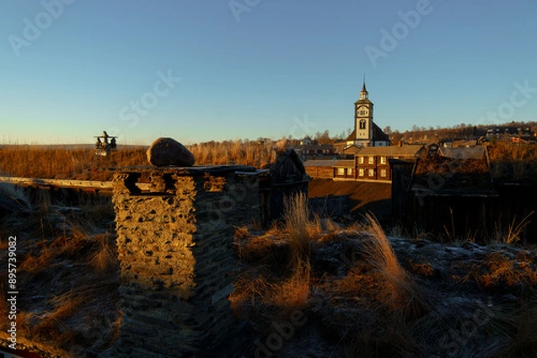 Obraz Sunset rays illuminate the charming landscape of Roros, featuring the town's landmark church and wooden architecture