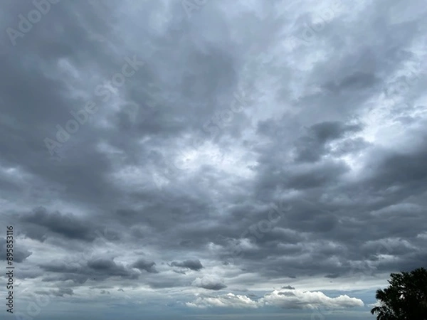 Obraz Image of a sky with dense rain clouds covering the entire sky. It's slightly smoky gray and white gives it a dull look.