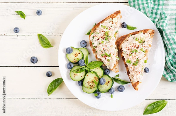 Fototapeta Toasts with tuna. Italian bruschetta sandwiches with pate canned tuna, egg and cucumber. Top view, flat lay,