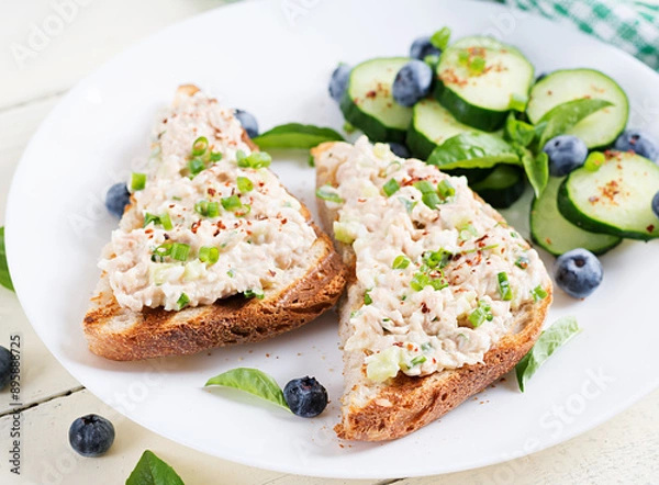 Fototapeta Toasts with tuna. Italian bruschetta sandwiches with pate canned tuna, egg and cucumber.