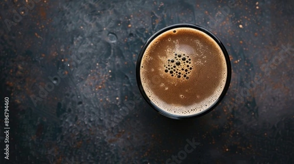 Fototapeta Glass of coffee-infused dark stout beer, top view on a dark background. Rich and creamy with a bold flavor profile