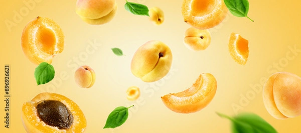 Fototapeta apricots group, slices and leaves flying on apricot colour background. Reference for design.