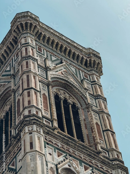 Fototapeta A tall building with a clock tower and a window on the top florence
