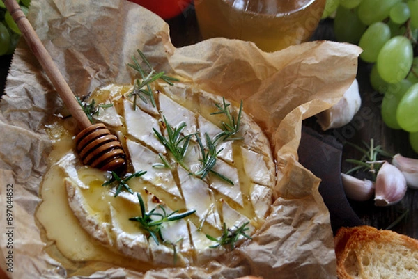 Obraz Baked camembert cheese with rosemary, garlic and honey on baking paper