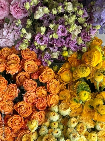 Fototapeta Beautiful fresh delphinium, roses, ranunculus, eustoma flowers in yellow and purple colors, vertical texture image, close up view 
