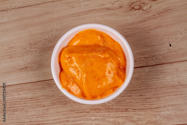 Fototapeta White Bowl of tasty chipotle sauce on wooden background