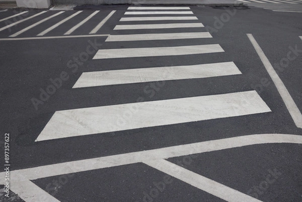 Fototapeta A black and white street with a white crosswalk