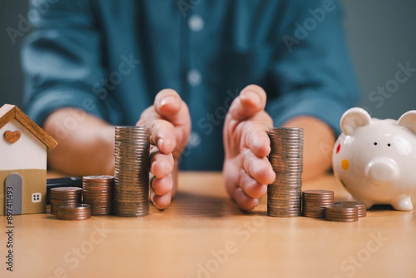 Obraz Divorce law and inheritance separation concept. Hand separate saving money, finance, home loan, debt return with piggybank and wood house. Bank business investment. Man separate stack coin on table