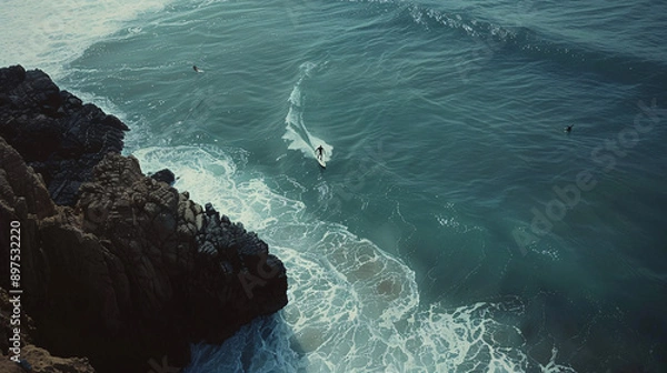 Fototapeta A lone surfer performing a maneuver on a large wave, with a tranquil beach setting and a few distant surfers in the background, captured in UHD 