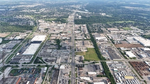 Fototapeta Aerial view of an urban industrial area with various buildings and greenery in the background