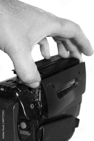 Fototapeta Video camera cassette loading.
Man loading a cassette into a video camera.