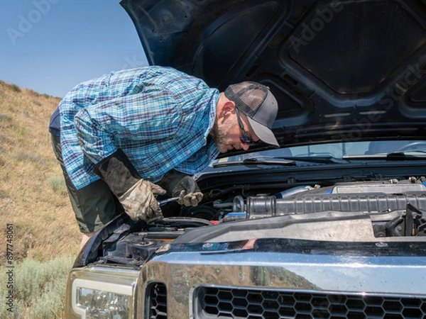 Obraz Blue pickup truck breaks down on the shoulder of a freeway while owner tries to assess the problem.